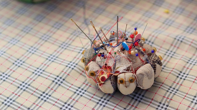 hands stitching fabric with needle thread calm crafting close-up