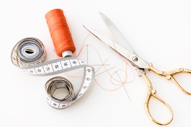 sewing workspace with scissors thread and soft pastel fabric